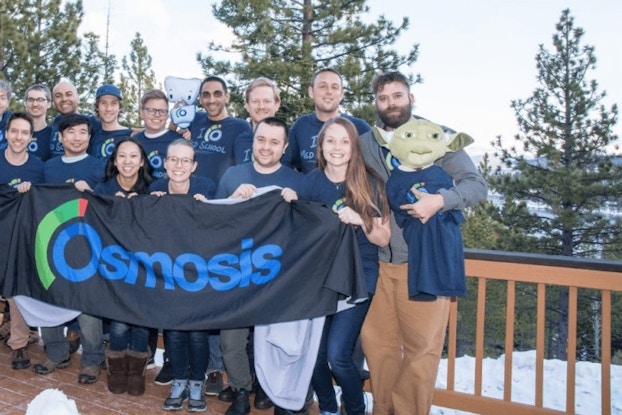  Group of colleagues stand on deck with company banner