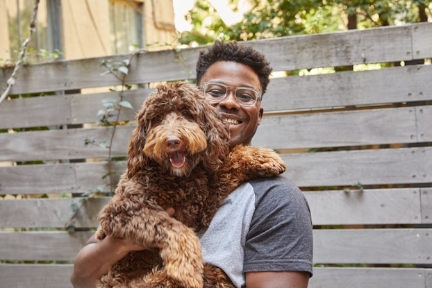  Renaldo Webb, founder of PetPlate, holding a dog.