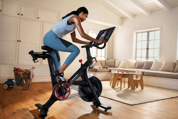  woman using peloton bike at home