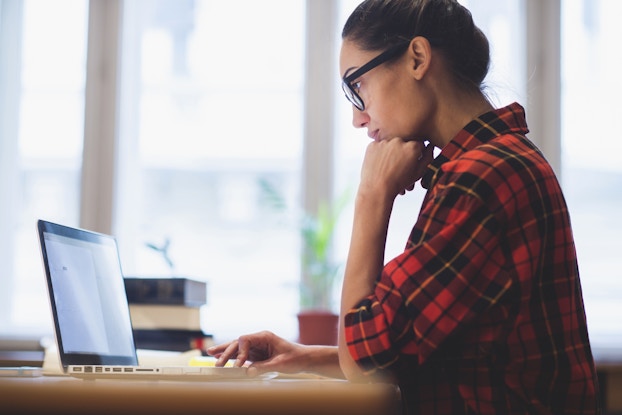  A young woman works on a laptop