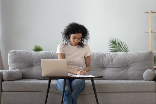  Woman works on document while working from home