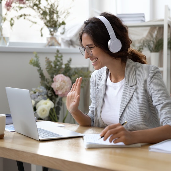 Woman greets virtual meeting attendees