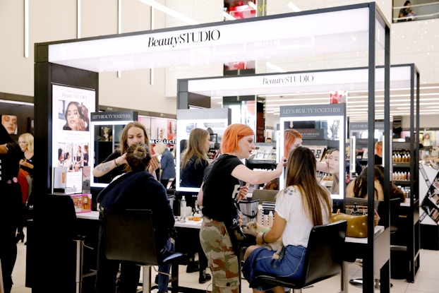  Customers getting makeovers by employees inside a Sephora location.