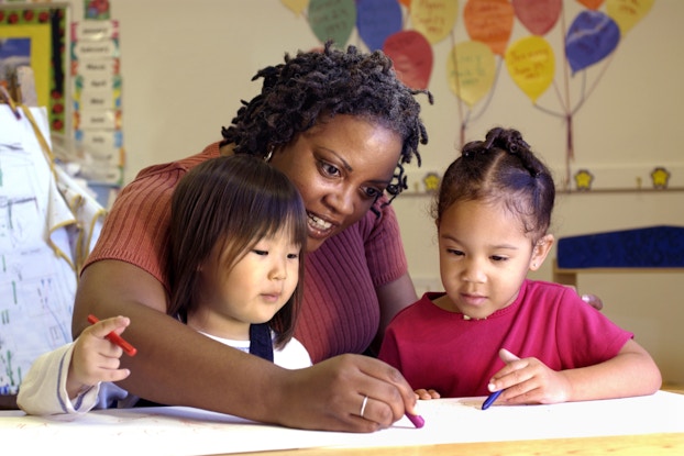 Daycare teacher draws with children
