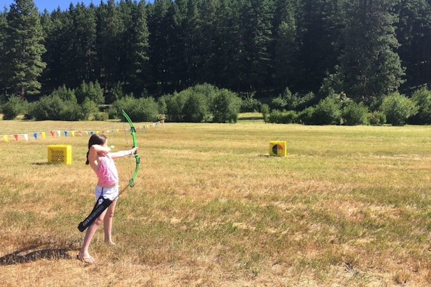  Woman taking archery lessons at Hyatt's Suncadia Resort.