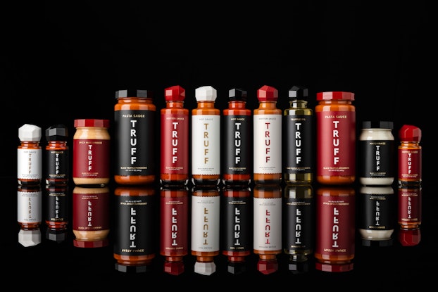 Bottles of TRUFF hot sauce in a row with a black background.