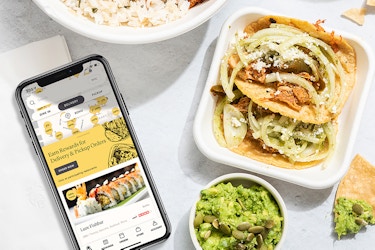  seated app on phon screen with takeout food 