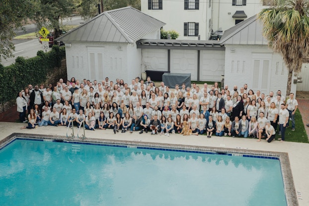  Business staff take a group photo near a building and pool