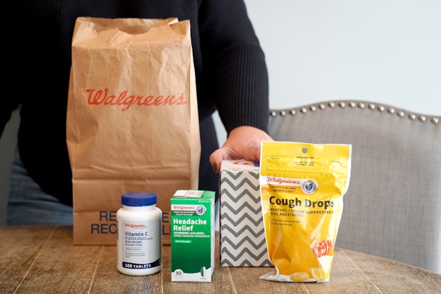  Walgreens cough and cold products displayed on a table in front of a Walgreens bag,