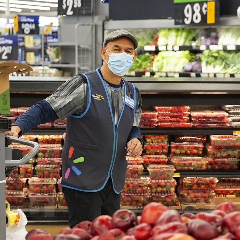  Walmart employee working with mask on in the produce section. 