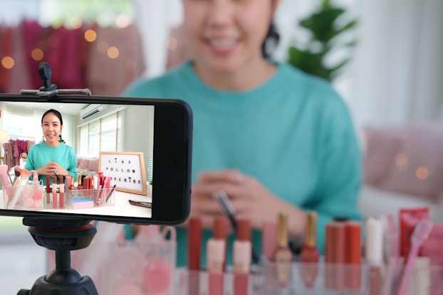  A woman microinfluencer records a live video in her home studio.