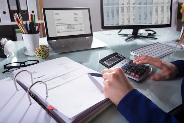 person at desk doing accounting tasks