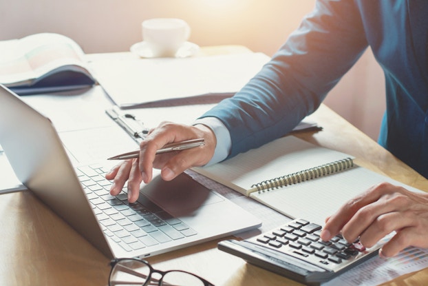 man using laptop and calculator