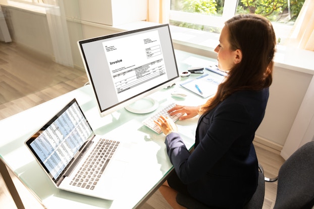  woman at computer looking at invoice