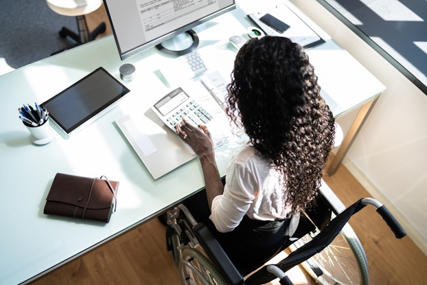 Woman working on accounting at her desk.