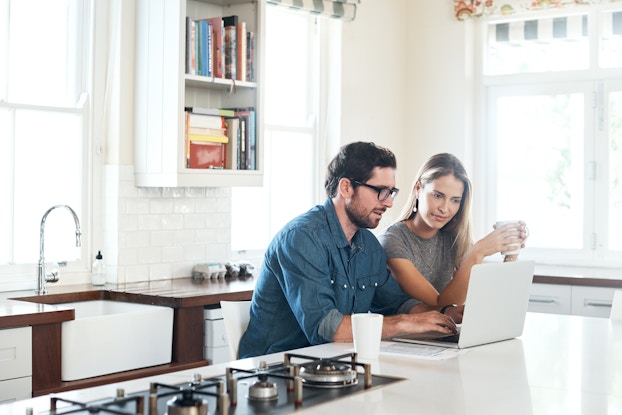 two people in kitchen working on laptop