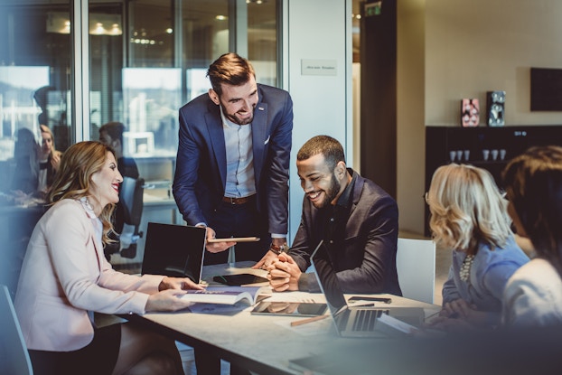  group of employees working at a table in office