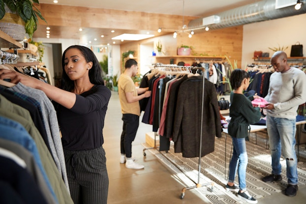 Customers and staff are pictured in a busy retail clothes store.