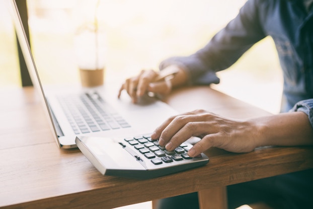 man using laptop and calculator