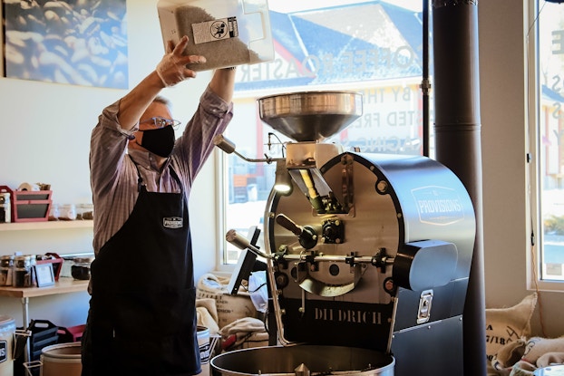  BD Provisions co-founder John Boccuzzi pouring beans into coffee roaster.