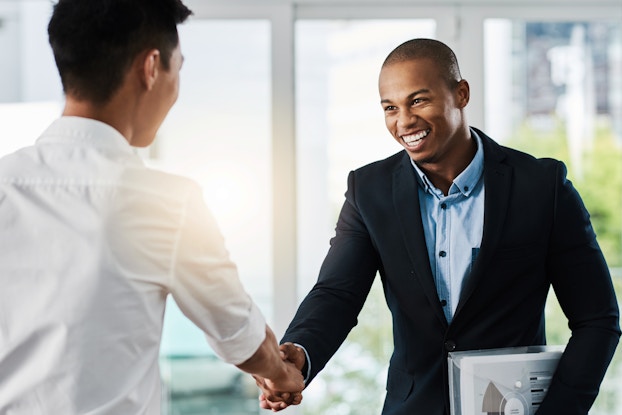  two men shaking hands in a meeting