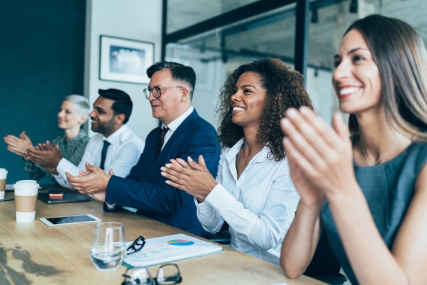  employees clapping while in meeting