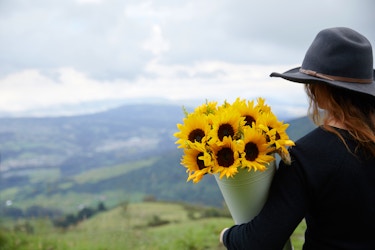  woman holding bouquet of sunflowers 