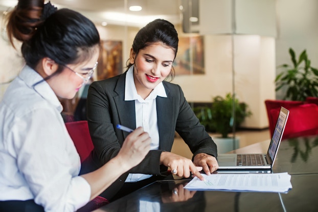 two women signing a contract