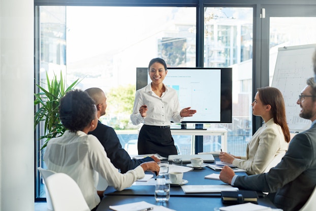  woman giving presentation to other professionals