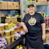a woman standing next to a shelf of food