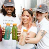 a group of people holding bottles of juice