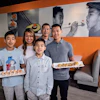a group of people holding plates of sushi