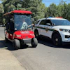 a golf cart and police car on the street