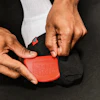 a person's hands sewing a red object