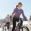 two women riding bikes on a road
