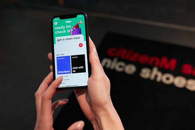 person holding phone with citizenM app open