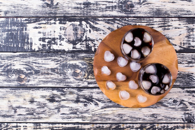 two glasses of soda with heart-shaped ice cubes on tray