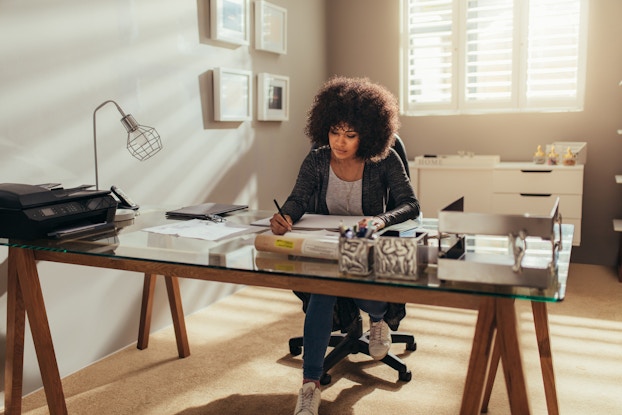  Woman working at desk in home office.