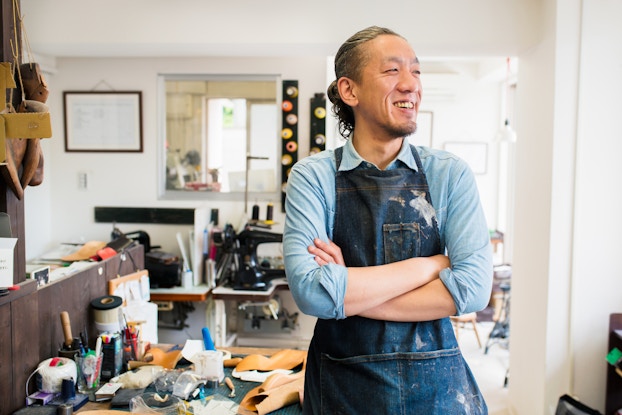  Portrait of a craftsman wearing an apron looking away from the camera.