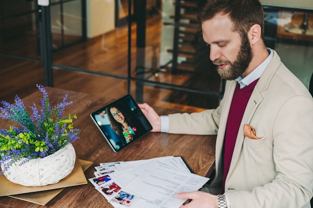 An employee reviews resumes while conducting a video interview.