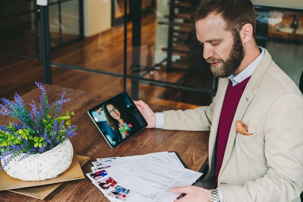  An employee reviews resumes while conducting a video interview.