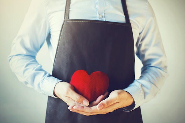  employee wearing apron holding heart