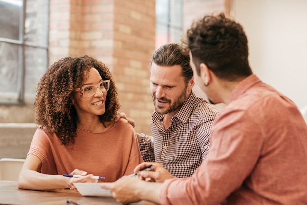  Two men and woman discussing document