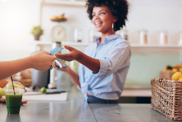  Female employee taking electronic payment from customer