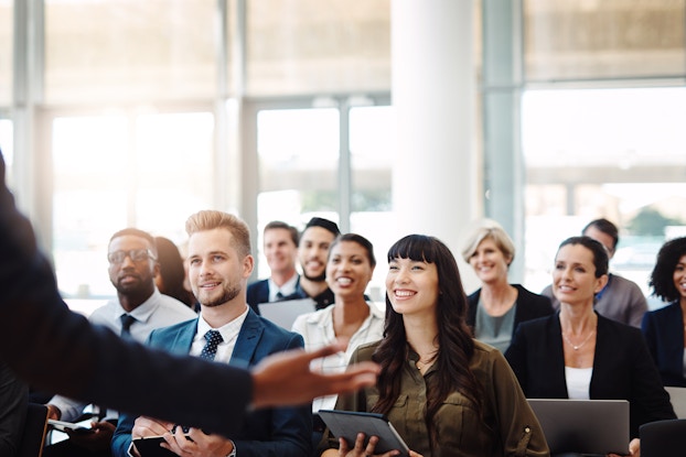 person presenting to a room of professionals