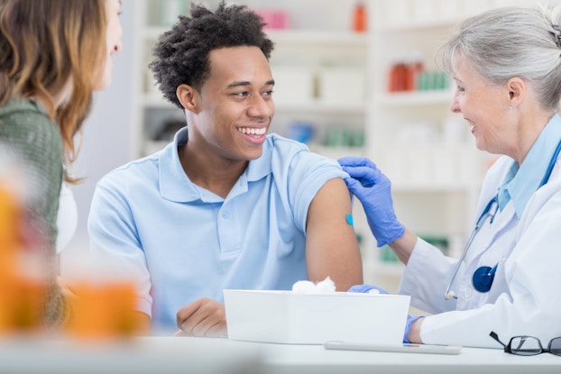  Man getting vaccinated by older woman.