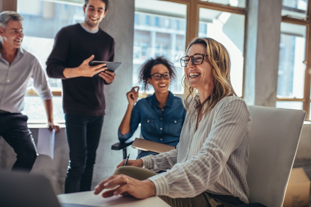  group of cheerful coworkers laughing and smiling