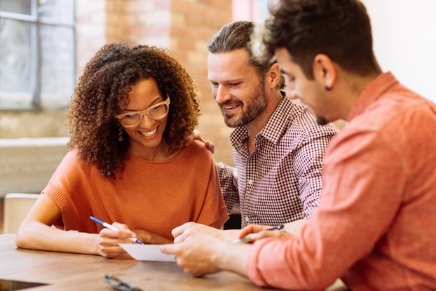 Three employees looking at document