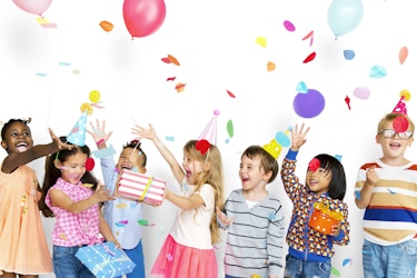  Group of happy kids playing with balloons and confetti. 