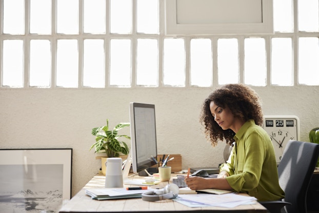  Woman working on laptop at a desk in an office.